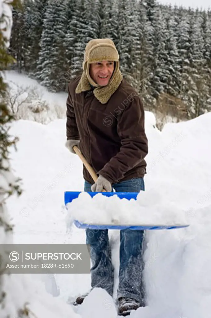Man Shovelling Snow, Hof bei Salzburg, Austria   