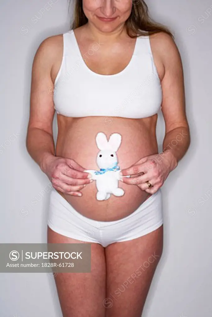Pregnant Woman Holding a Stuffed Animal on Belly   