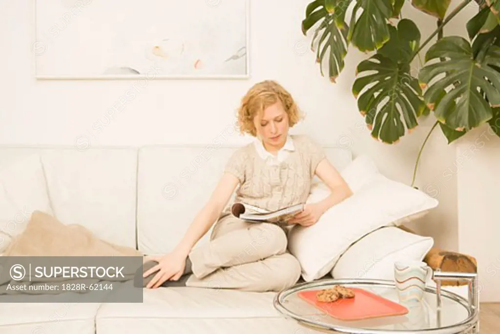 Woman Sitting on Sofa Reading   