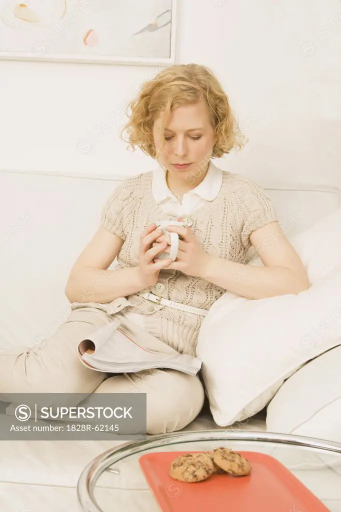 Woman Sitting on Sofa Reading   