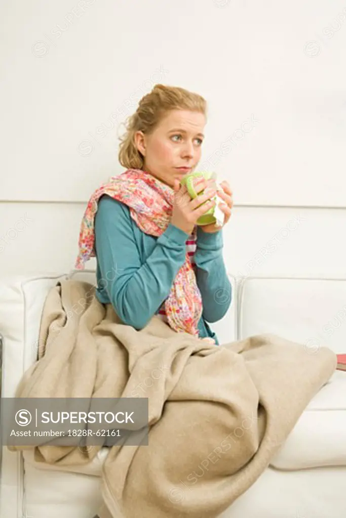 Woman holding Mug Sitting on Sofa   