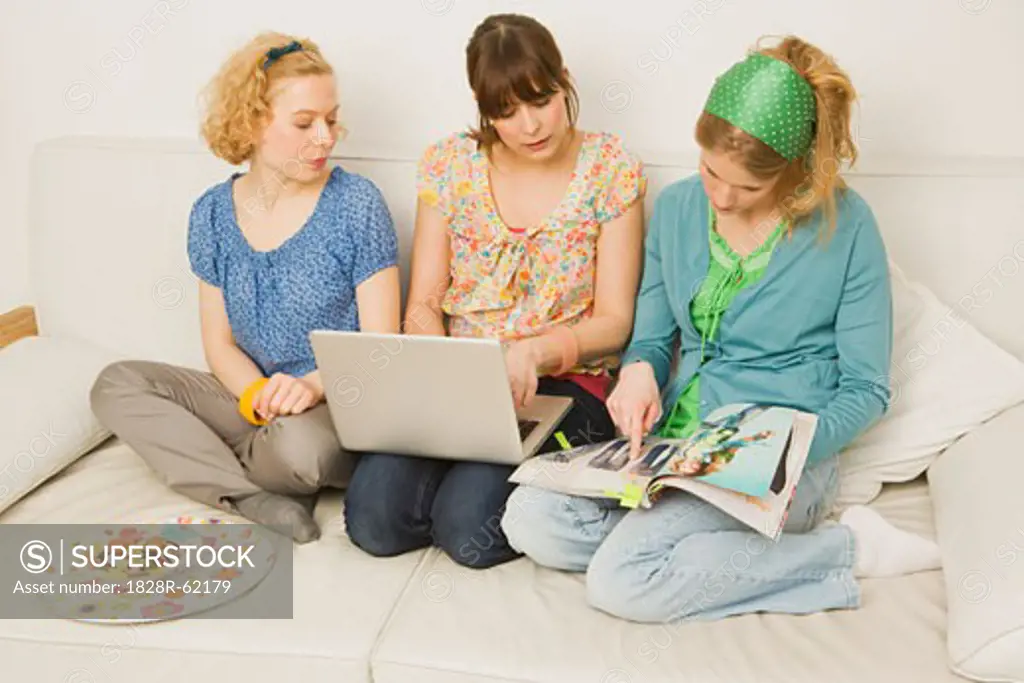 Women Sitting on Sofa Shopping On-line   
