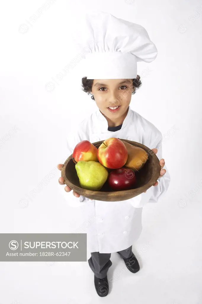 Boy Dressed Up as a Chef Holding Bowl of Fruit