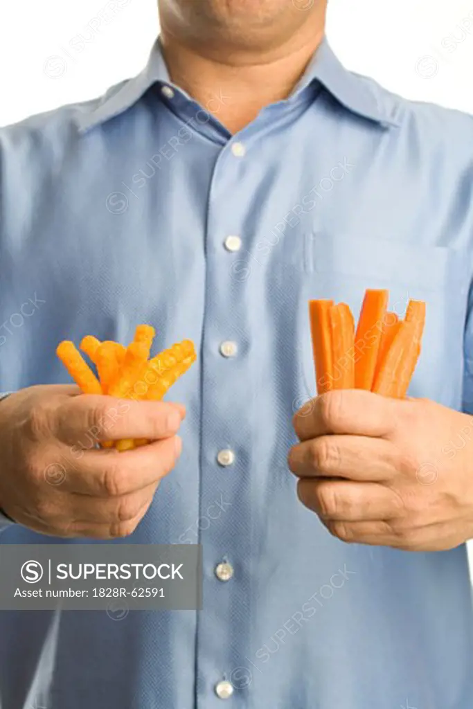 Man Holding Cheesies in One Hand and Carrot Sticks in the Other