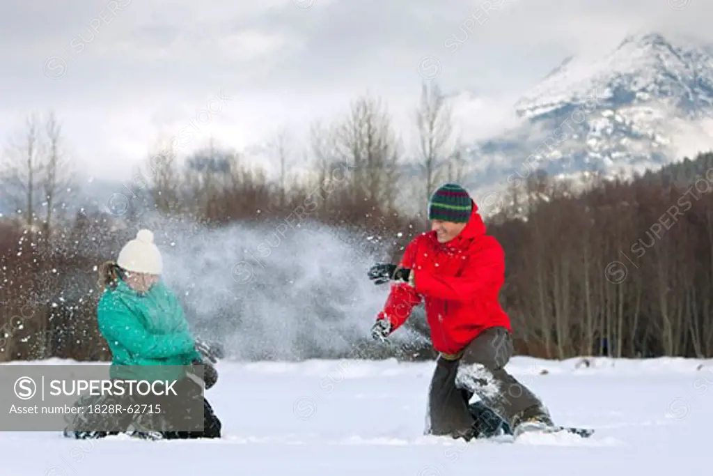 Couple Wearing Snowshoes having a Snowball Fight, Whistler, Bristish Columbia, Canada