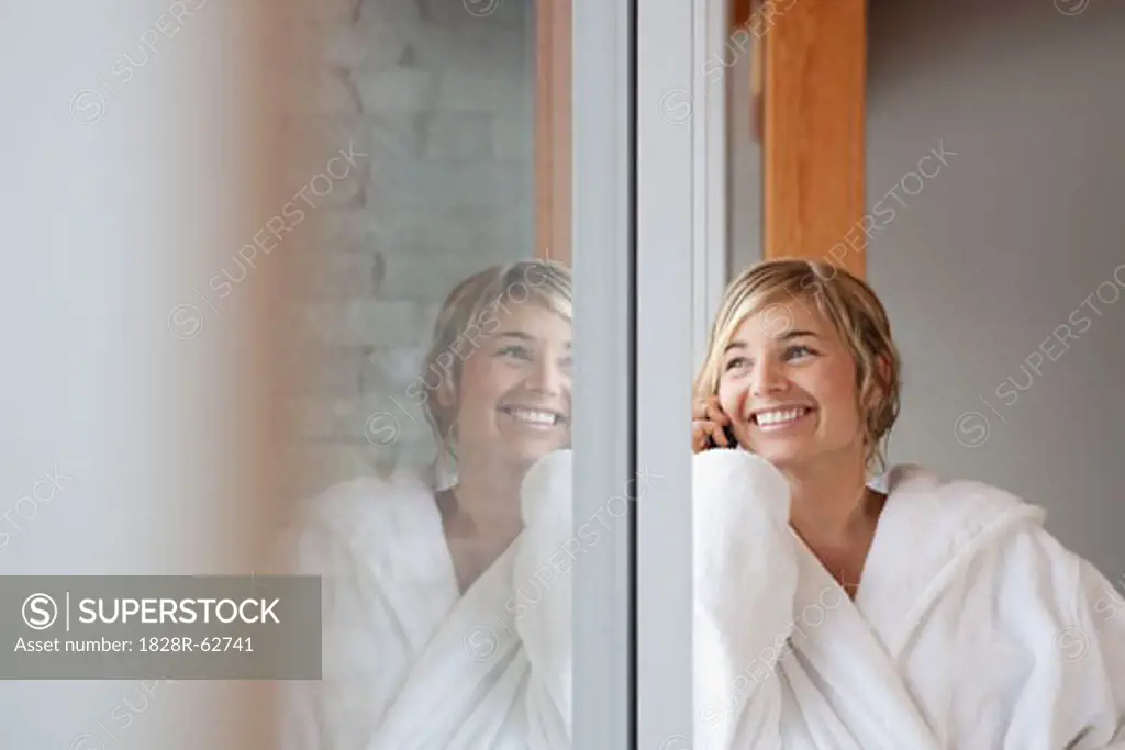 Woman in Bathrobe Talking on Cell Phone and Looking Out the Window