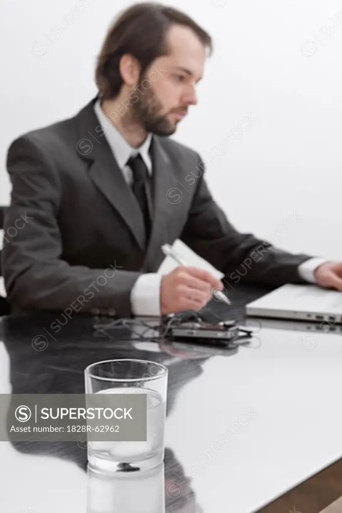 Tablets Dissolving in Glass of Water on Businessman's Desk