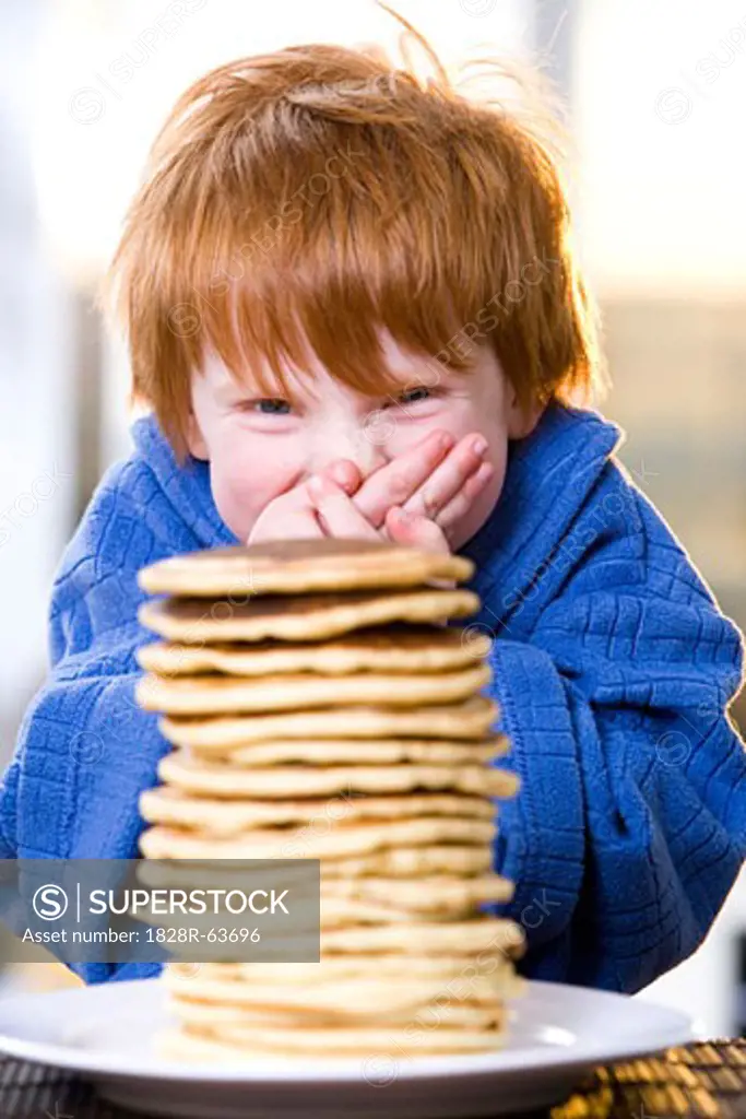 Happy Little Boy With a Stack of Pancakes