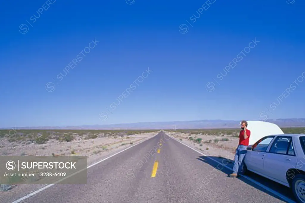 Person on Cell Phone by Stranded Car, Nevada, USA   