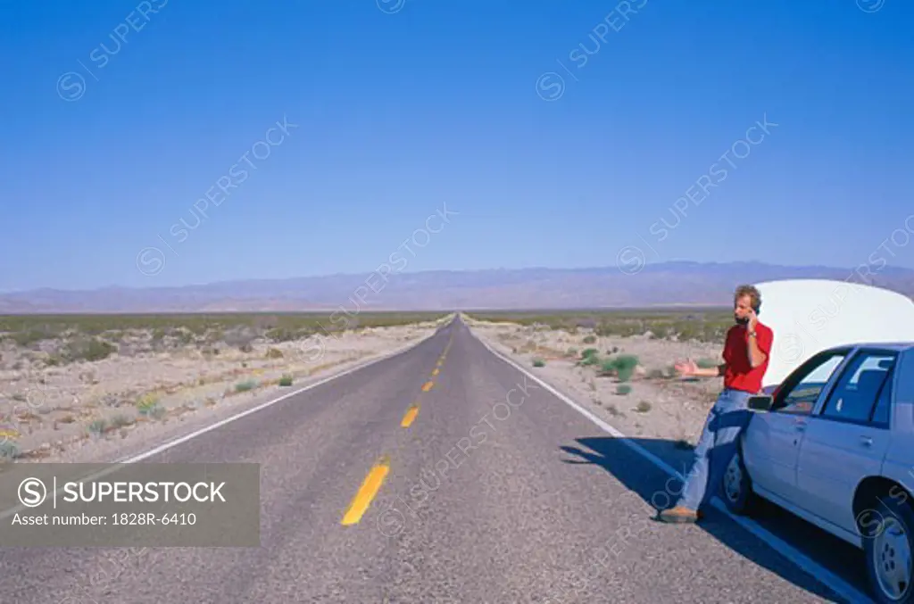 Person on Cell Phone by Stranded Car, Nevada, USA   