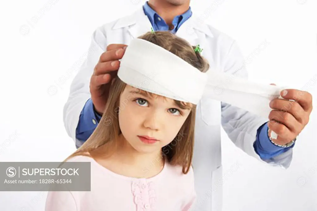 Doctor Wrapping Bandage Around Girl's Head