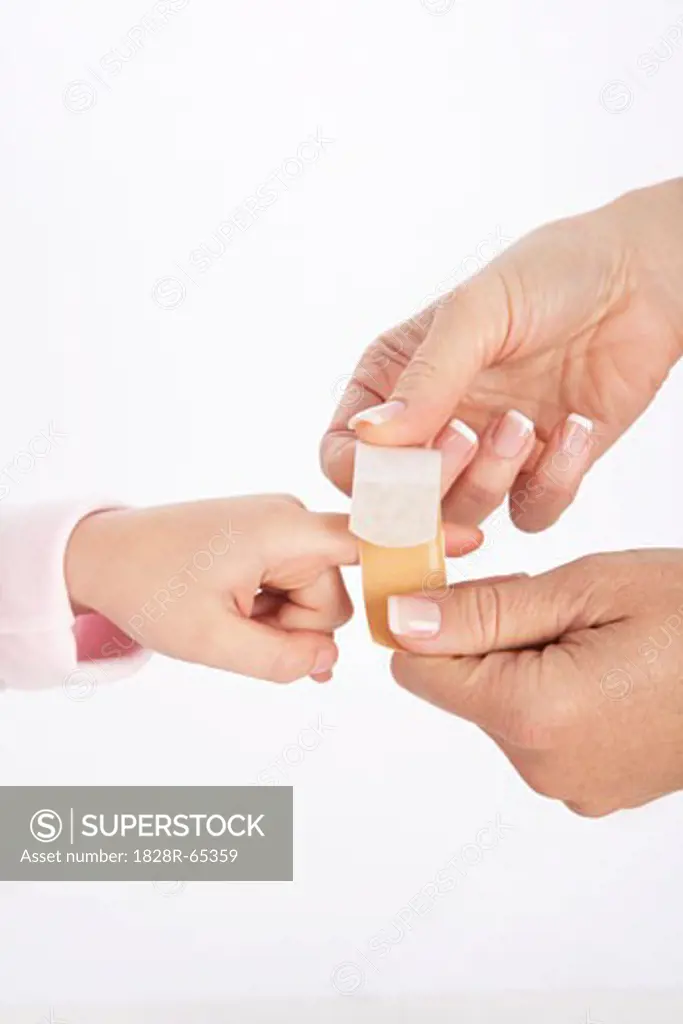 Mom Putting Bandaid on Daughter's Finger