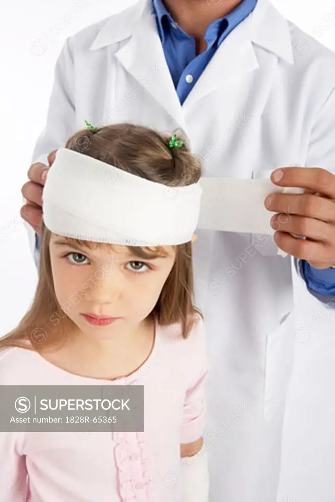 Doctor Wrapping Bandage Around Girl's Head