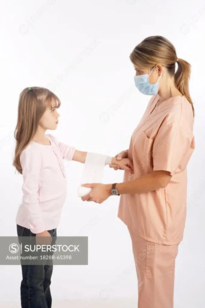 Nurse Wrapping Bandage Around Girl's Arm