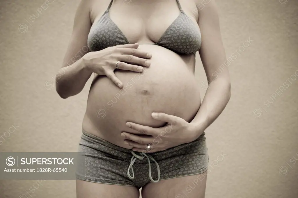 Woman, Nine Months Pregnant, Touching Her Belly