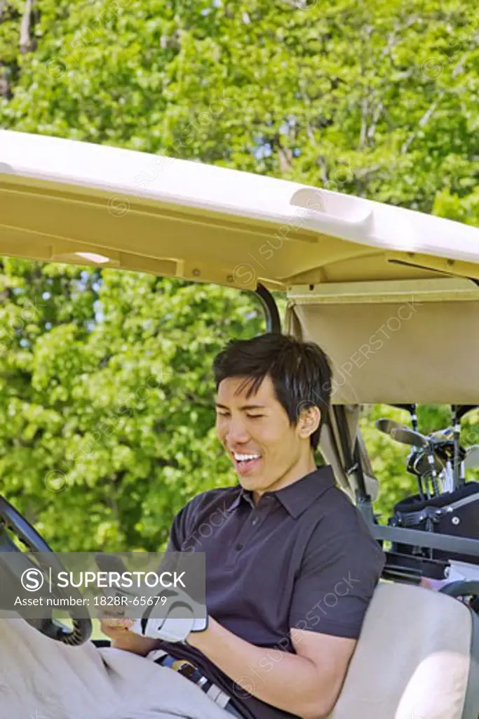 Man in Golf Cart Reading Text Message