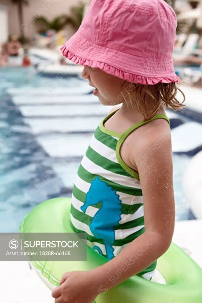 Little Girl With Inner Tube Playing on Pool Deck