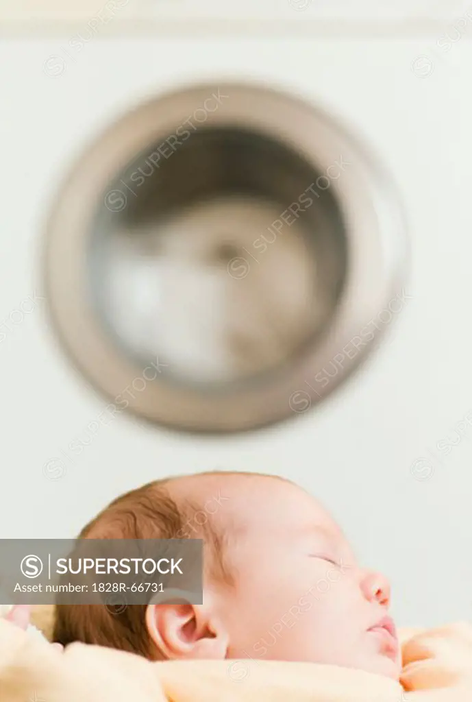 Baby Sleeping near Washing Machine