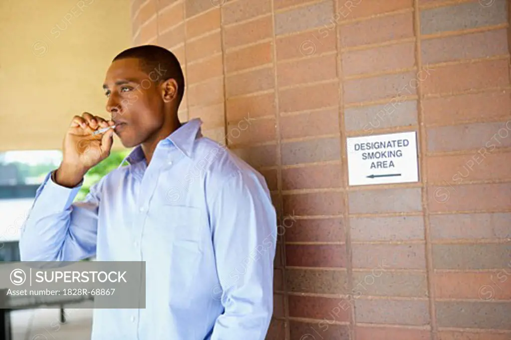 Man Smoking a Cigarette in Designated Area