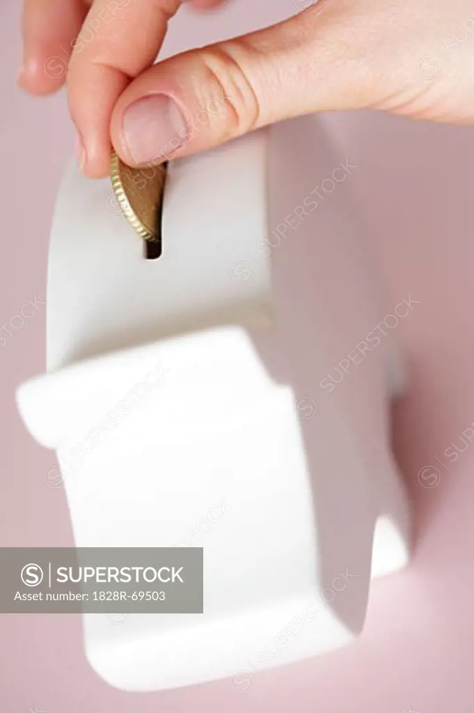 Person Putting Coin in Piggy Bank