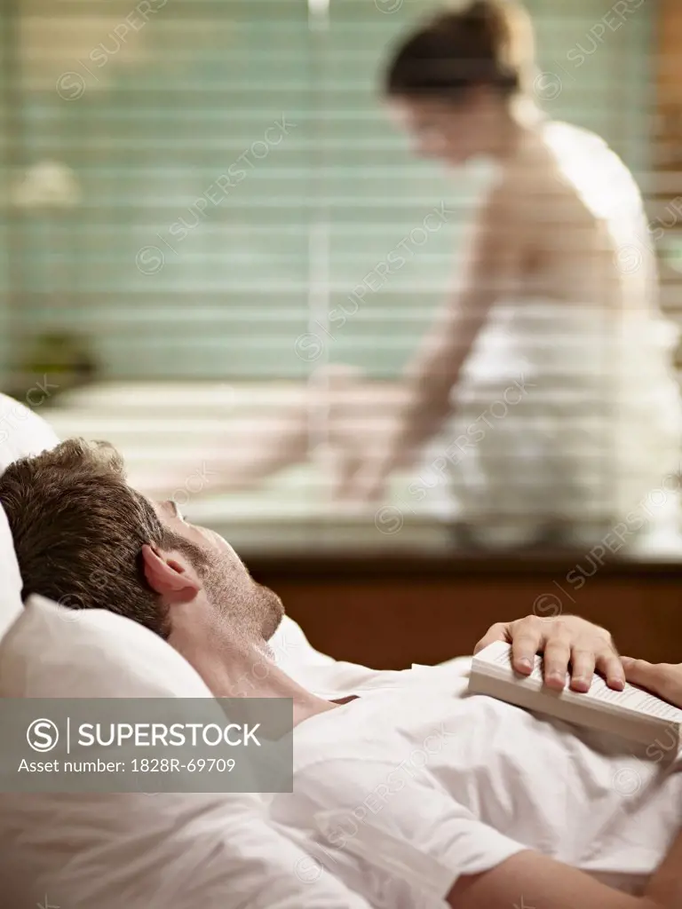 Man Lying in Bed Watching Woman Getting Ready to Take a Bath