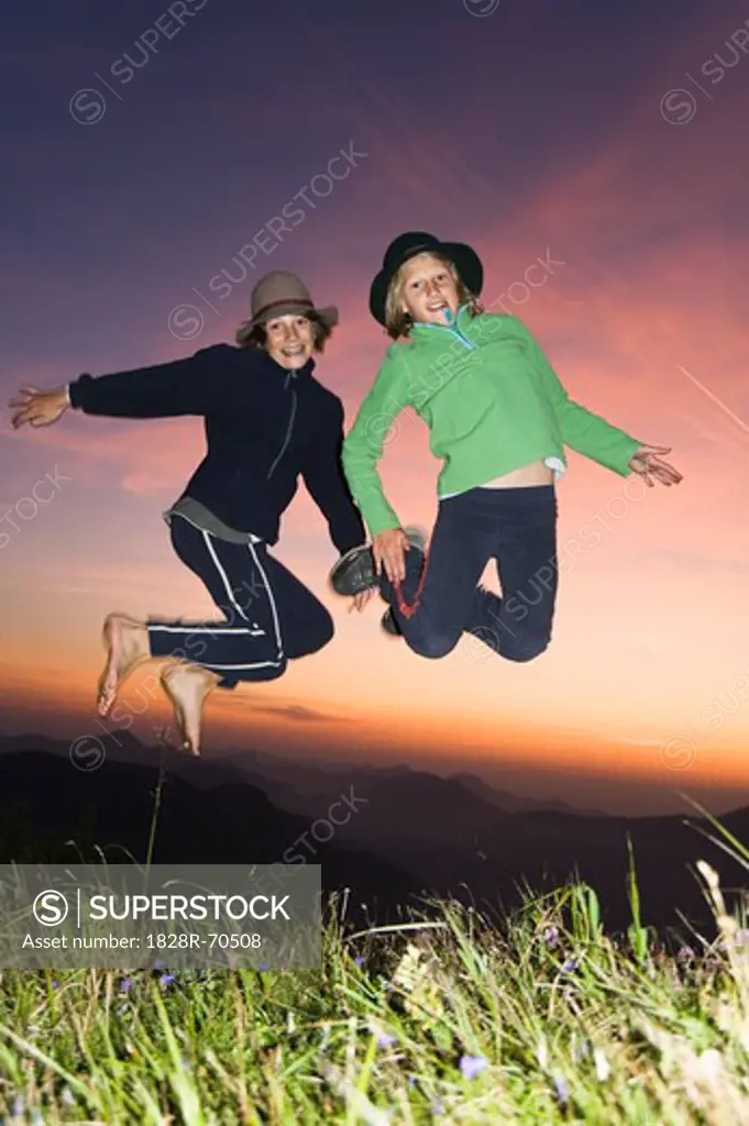 Girl and Boy Jumping in Air, Untersberg, Bavaria, Germany