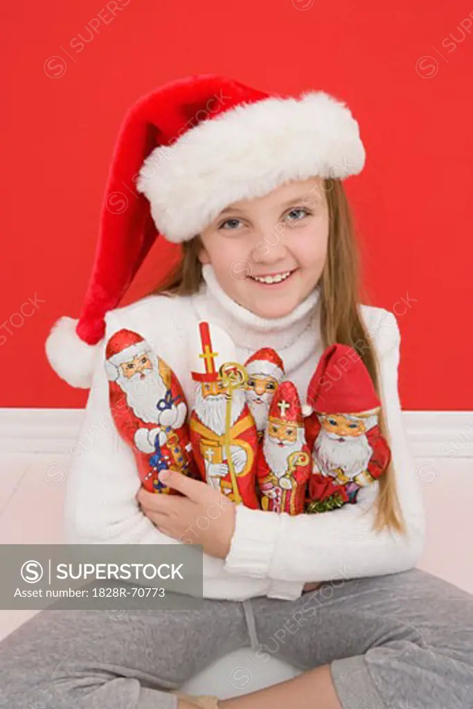 Portrait of Girl Holding Santa Ornaments Wearing Santa Hat