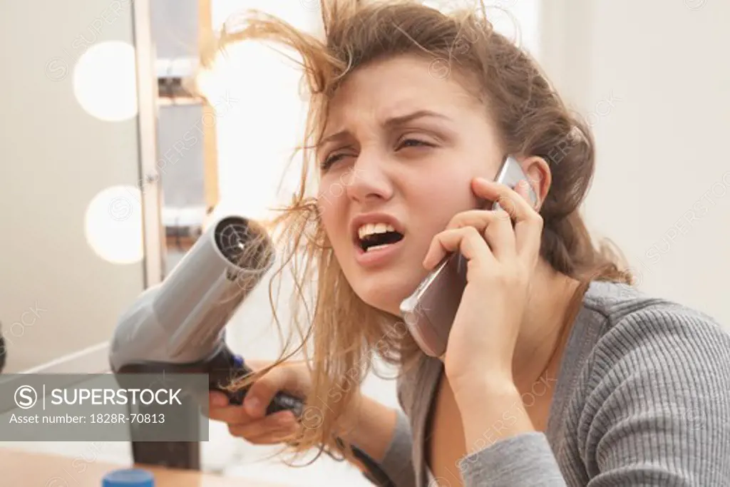 Close-up of Woman using Hair Dryer and Talking on Cell Phone