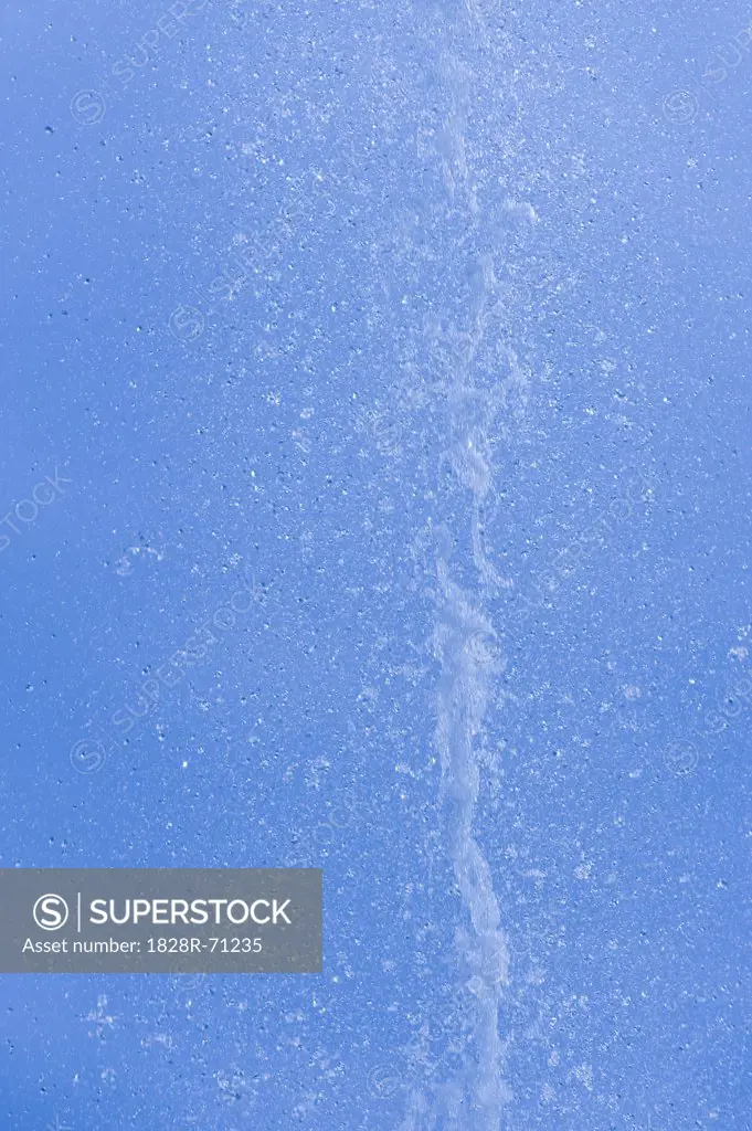 Water Drops from Water Fountain against Blue Sky