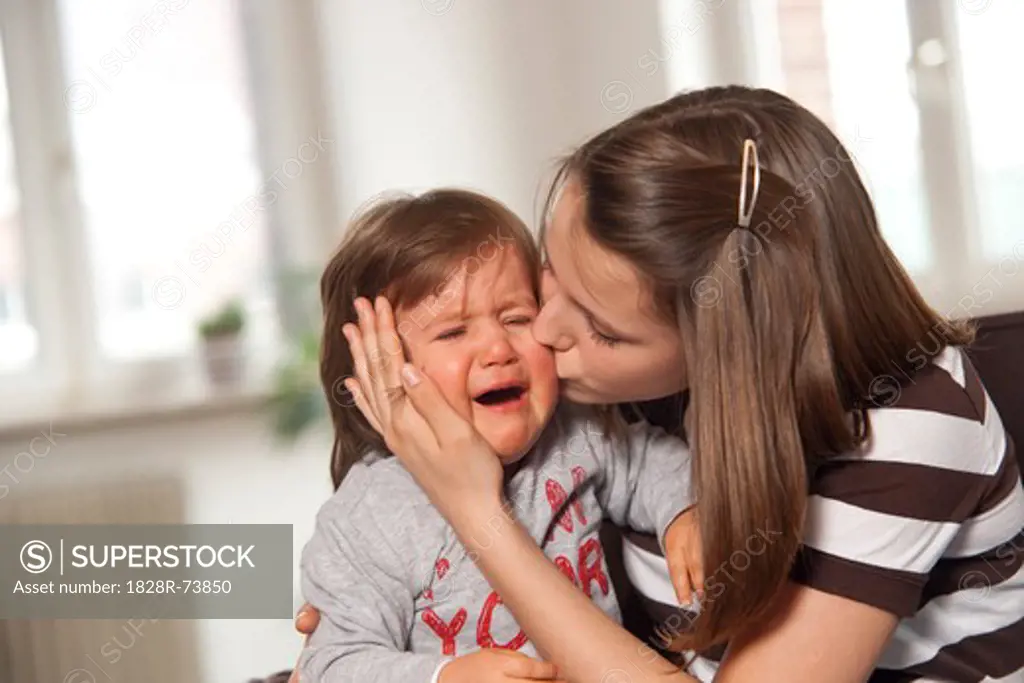 Teenage Girl Kissing Crying Baby Boy