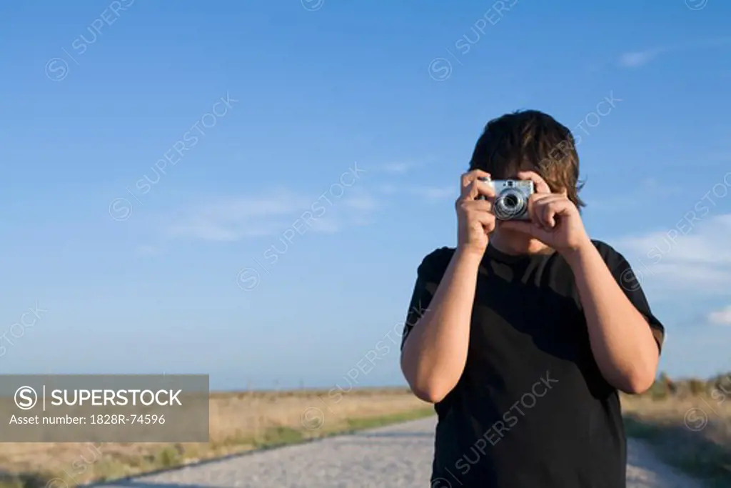 Boy Taking Photograph in Field