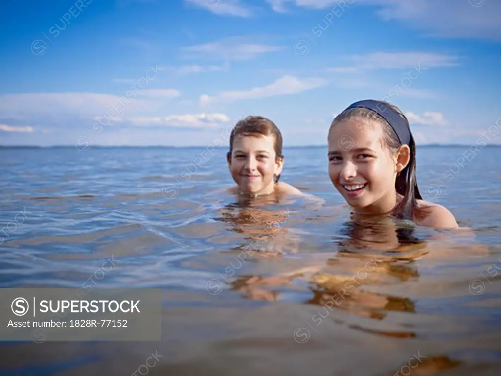 Boy and Girl Swimming in Lake