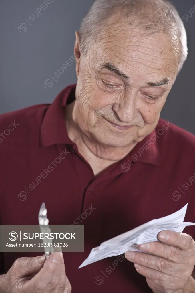 Man Looking at Blister Pack of Pills