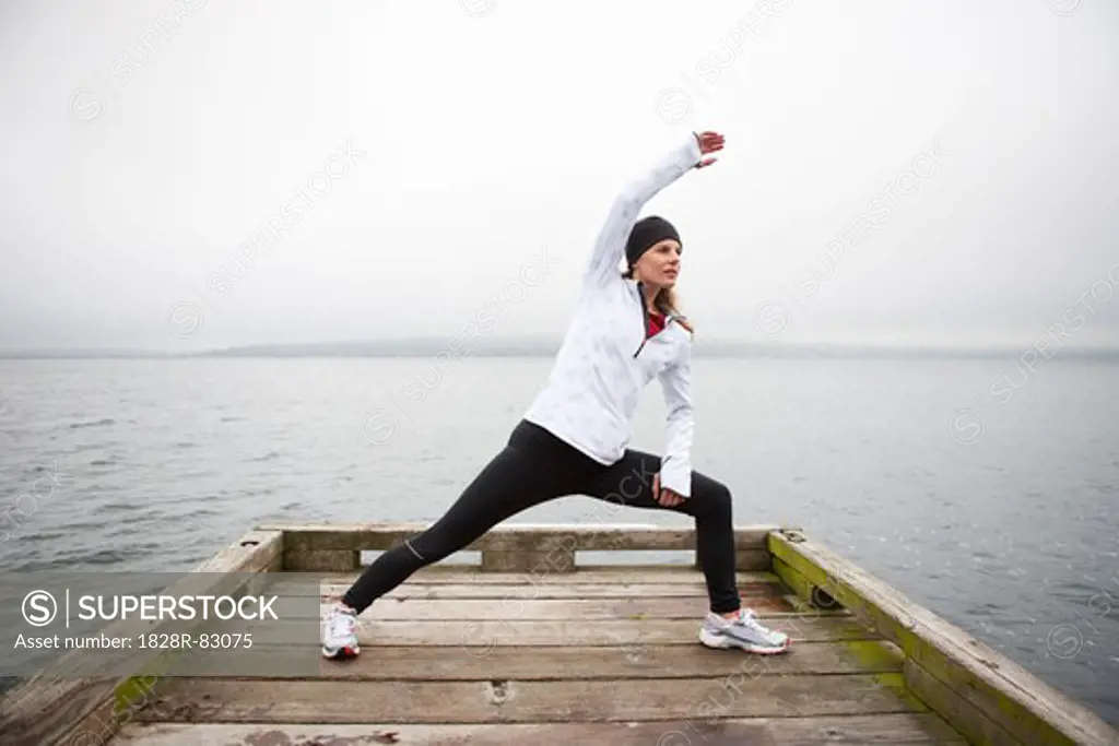 Woman Stretching on Dock before Jogging, , Puget Sound, Seattle, Washington, USA