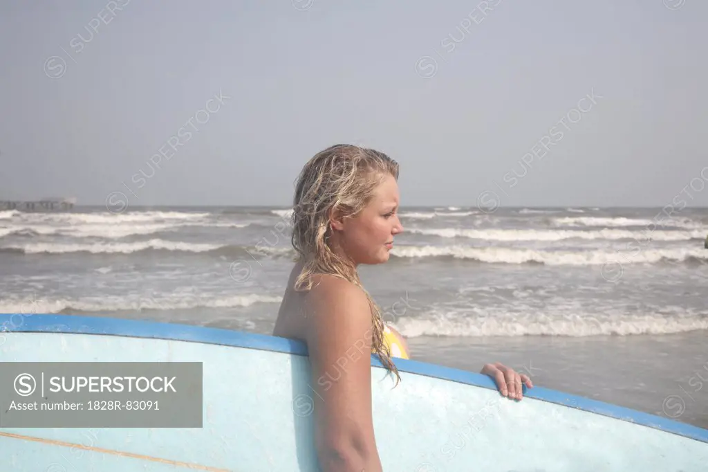 Young Woman holding Surfboard on Beach, Galveston Beach, Galveston, Texas, USA