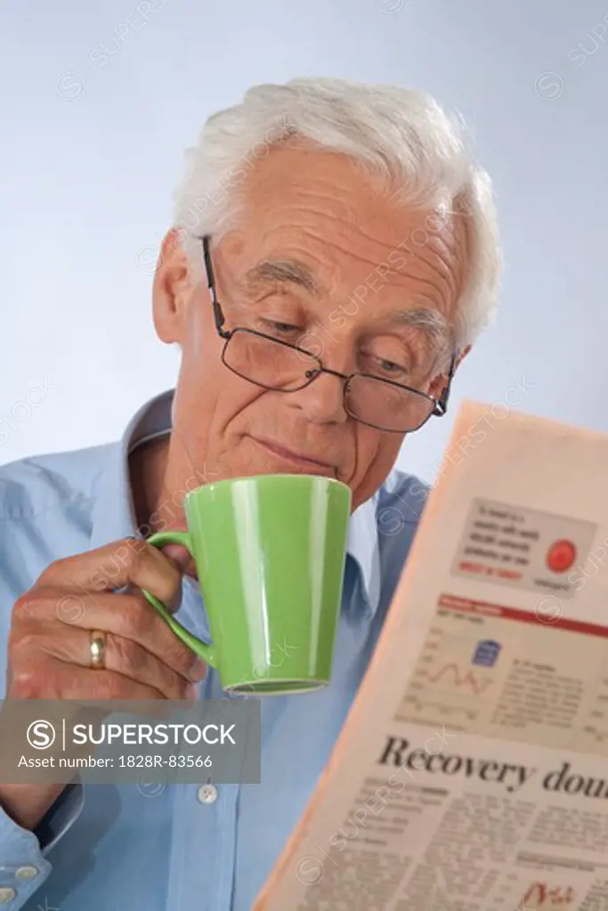 Man Drinking Coffee and Reading Newspaper