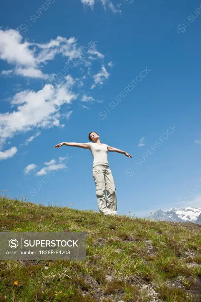 Woman Standing on Mountain Side with Arms Outstretched, Bernese Oberland, Switzerland