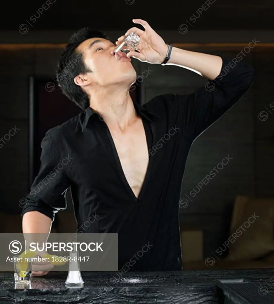 Man Drinking Shot at Bar   
