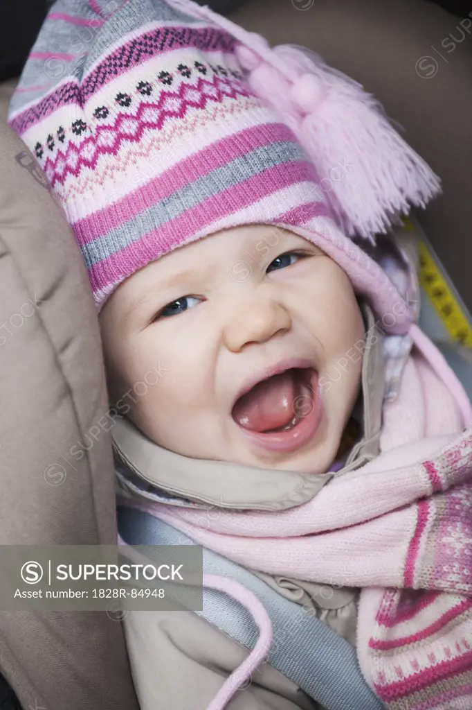 Close-up of Baby Girl Sitting in Car Seat wearing Winter Clothing
