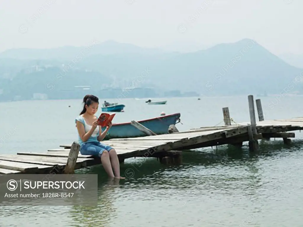 Woman Reading on Dock   