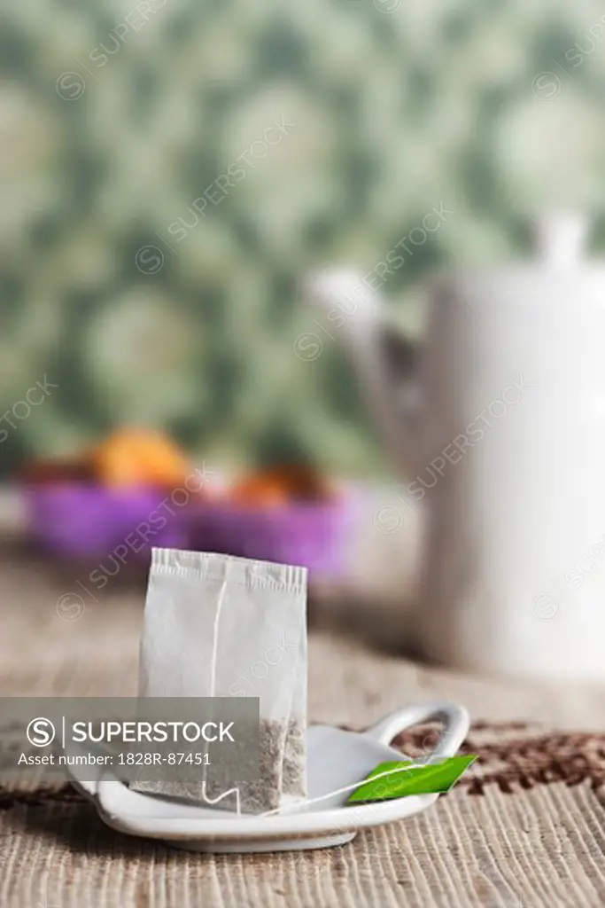 Tea Bag on Holder with Teapot in Background
