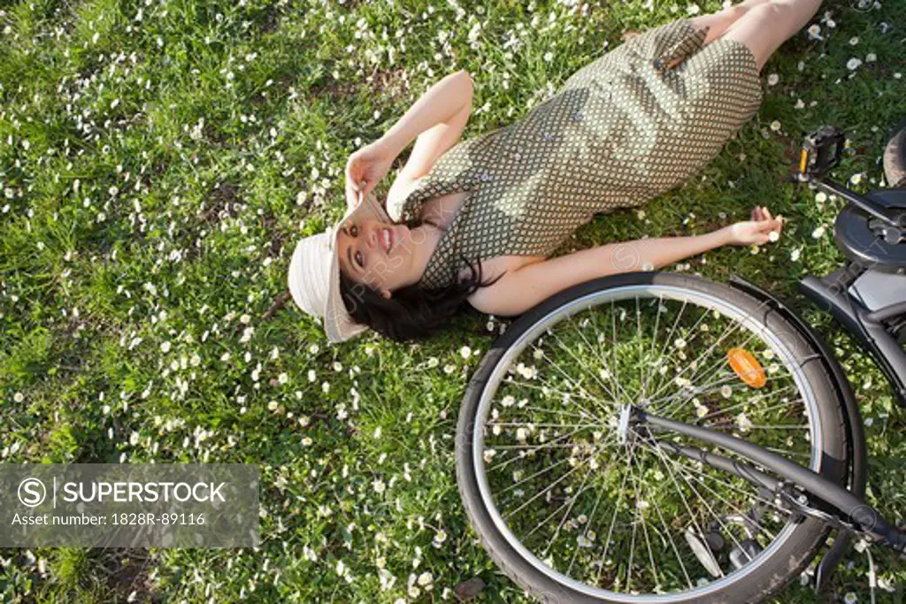 Woman Lying in Grass with Bicycle