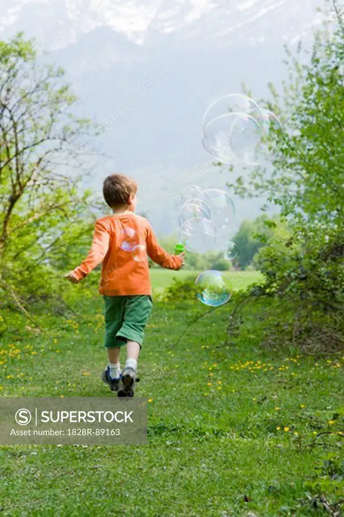 Boy Running and Blowing Bubbles, Salzburg, Austria