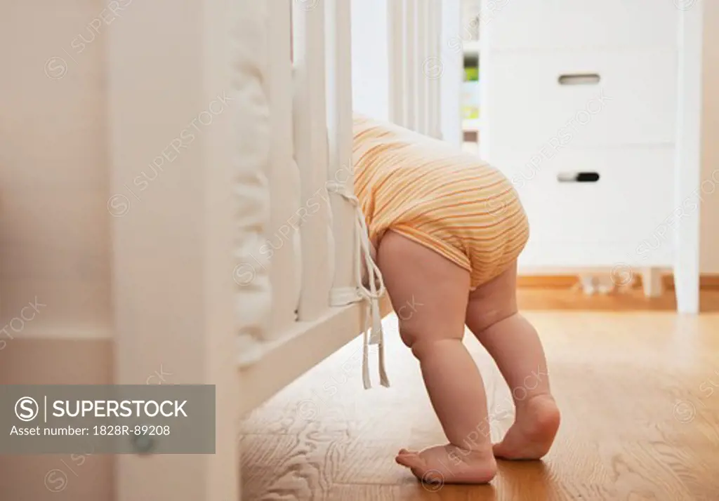 Baby Girl Climbing into Crib