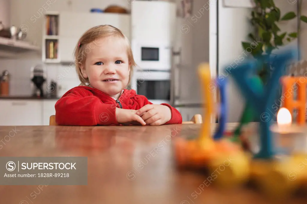 Portrait of Little Girl Sitting at Table