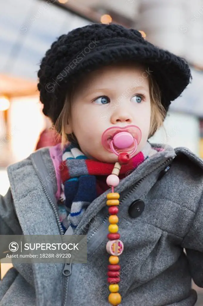 Portrait of Little Girl using Pacifier wearing Winter Cothes