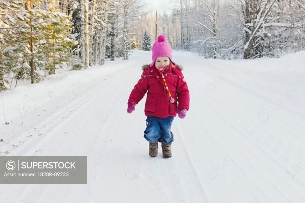 Portrait of Little Girl Walking Down Road in Winter