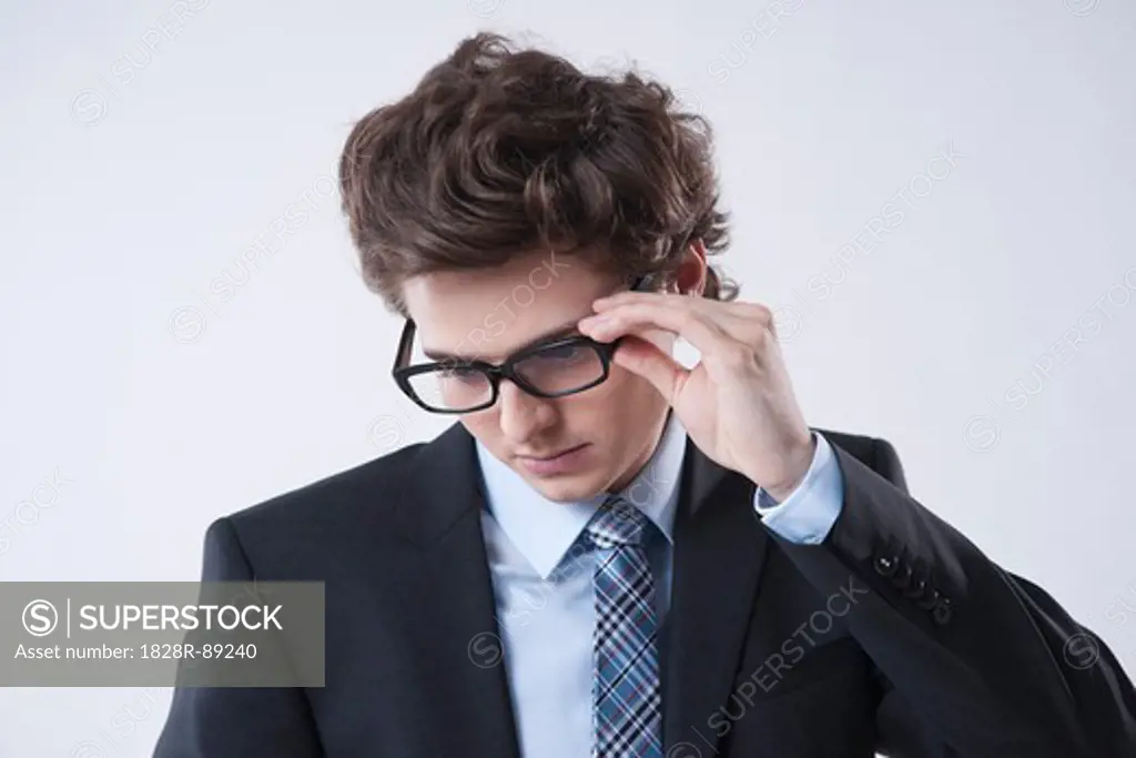 Portrait of Young Businessman Looking Down and wearing Eyeglasses