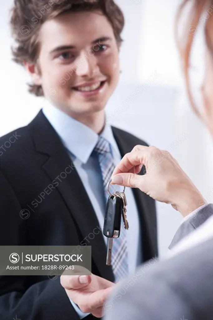 Businessman Receiving Keys from Businesswoman