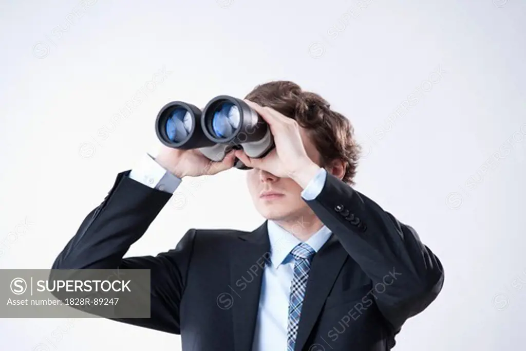 Young Businessman Looking through Binoculars